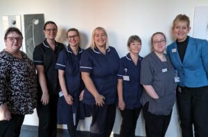 The infant feeding team standing in a line, smiling. 
