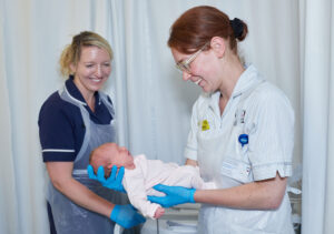 Two midwives looking at a baby