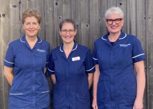 Three members of the NICU Outreach team standing in a row in their blue uniforms