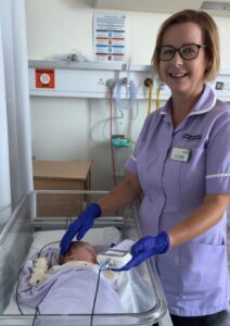 carrying out a hearing check on a new born baby