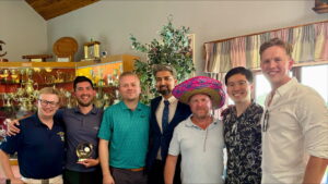 A group of seven holding a golf trophy
