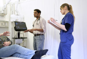 A doctor and nurse at a patient's bedside.